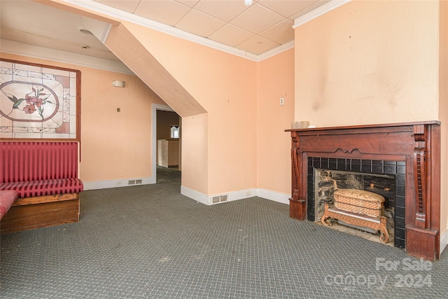 unfurnished living room featuring carpet flooring, a tiled fireplace, and ornamental molding