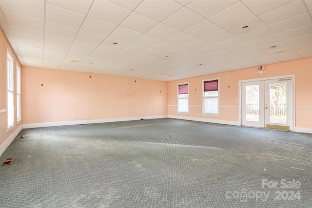 empty room featuring carpet flooring, plenty of natural light, and french doors