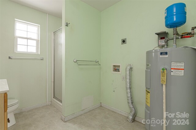 bathroom with vanity, toilet, a shower with shower door, and water heater