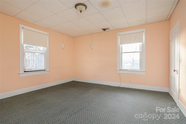 spare room featuring a paneled ceiling and carpet