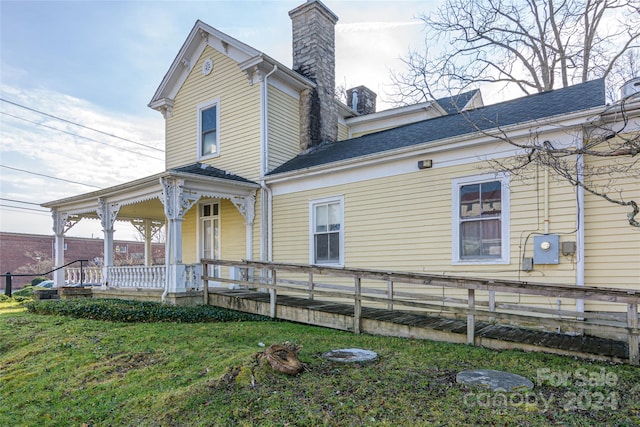 rear view of house with a lawn and a porch