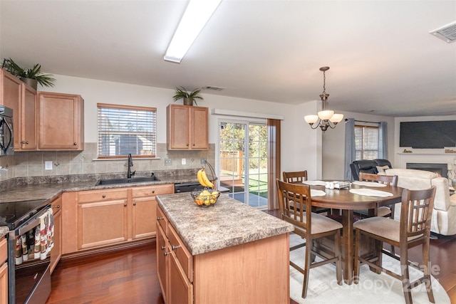 kitchen featuring dark hardwood / wood-style flooring, a kitchen island, a wealth of natural light, and sink