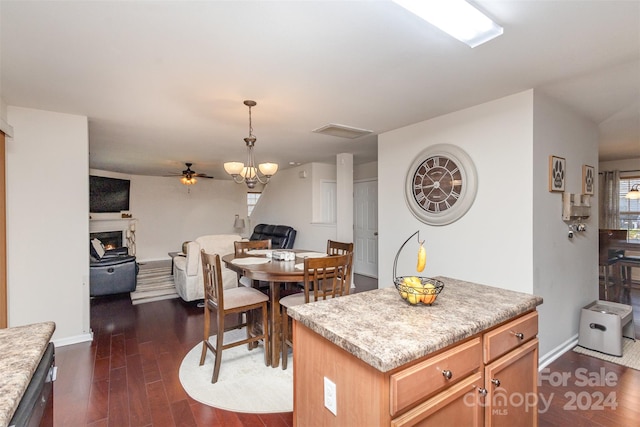 kitchen with ceiling fan, a kitchen island, and dark wood-type flooring