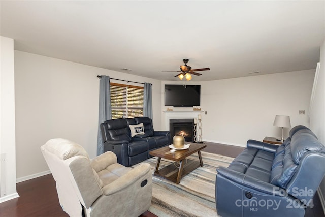 living room featuring ceiling fan and dark wood-type flooring