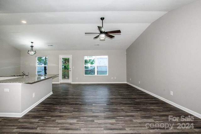 unfurnished living room with a healthy amount of sunlight, dark wood-type flooring, and lofted ceiling