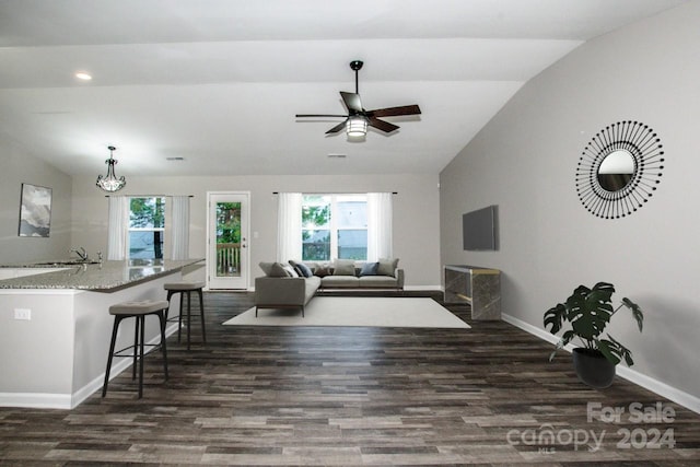 living room featuring lofted ceiling, dark hardwood / wood-style floors, ceiling fan, and a healthy amount of sunlight