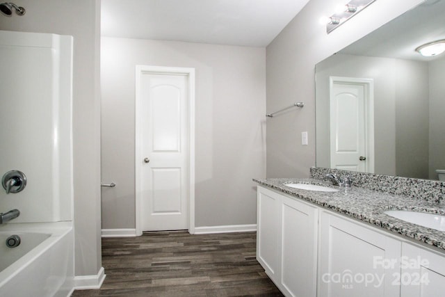 bathroom featuring vanity, hardwood / wood-style flooring, and shower / washtub combination