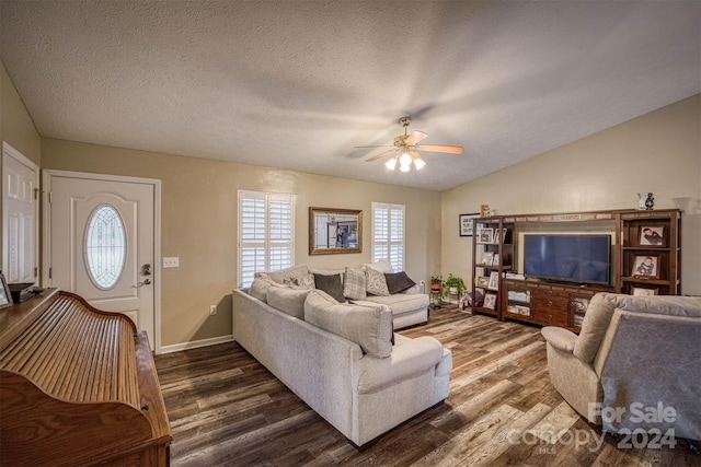 living room featuring lofted ceiling, ceiling fan, a healthy amount of sunlight, and dark hardwood / wood-style flooring