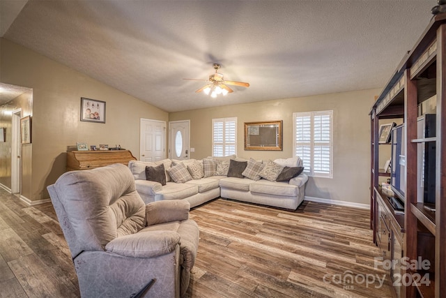 living room featuring ceiling fan, wood-type flooring, a textured ceiling, and lofted ceiling