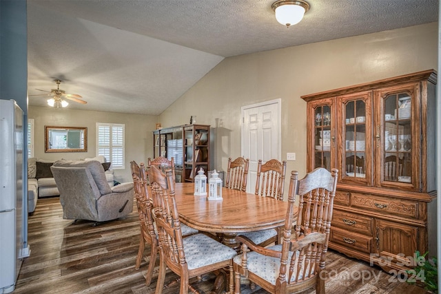 dining room with dark wood-type flooring, ceiling fan, a textured ceiling, and vaulted ceiling