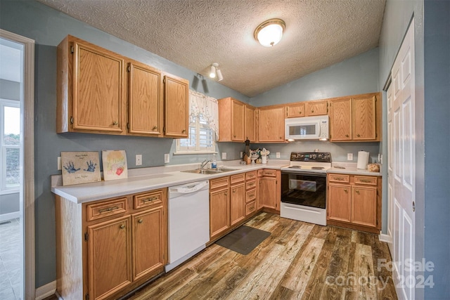 kitchen featuring hardwood / wood-style floors, white appliances, plenty of natural light, and vaulted ceiling