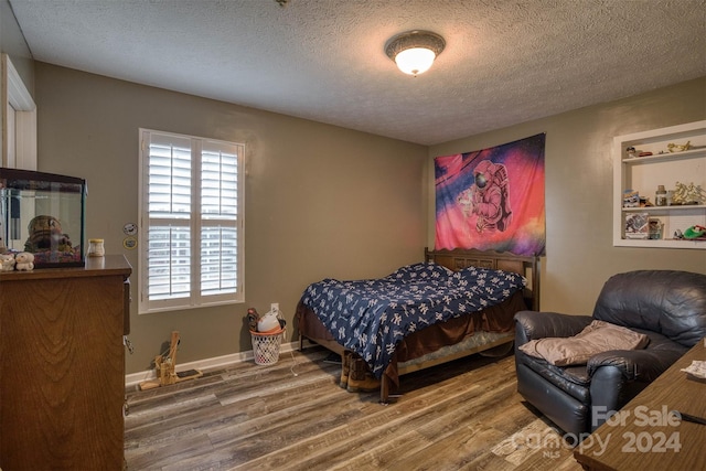 bedroom featuring hardwood / wood-style flooring and a textured ceiling