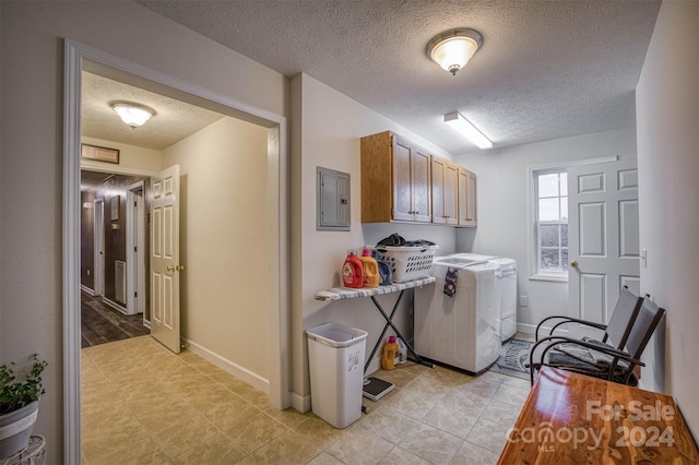 laundry room featuring cabinets, a textured ceiling, light tile patterned floors, washer and clothes dryer, and electric panel