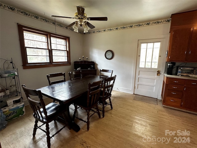 dining space with light hardwood / wood-style floors and ceiling fan