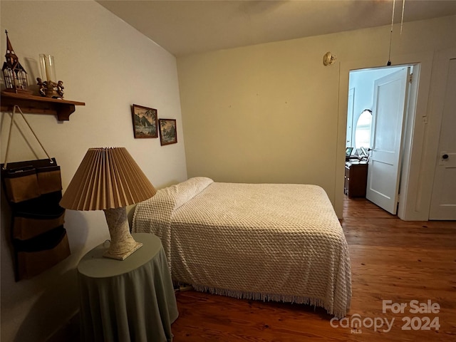 bedroom with dark wood-type flooring