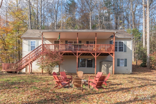 back of house featuring a deck, a yard, and an outdoor fire pit