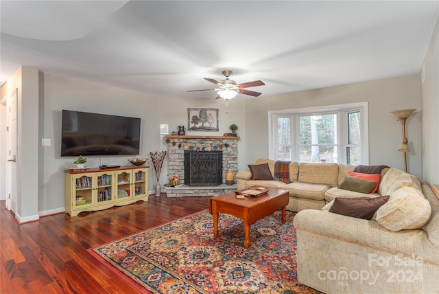 living room with a stone fireplace, hardwood / wood-style flooring, and ceiling fan