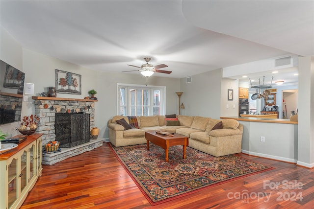 living room with wood-type flooring, ceiling fan, and a fireplace