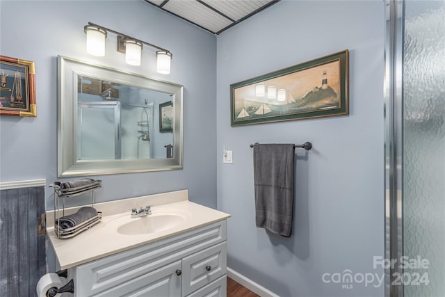 bathroom with hardwood / wood-style flooring, vanity, and a shower with door