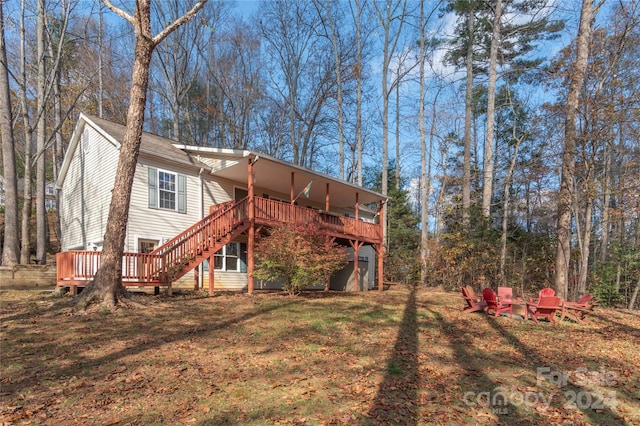 rear view of house with a wooden deck and a yard