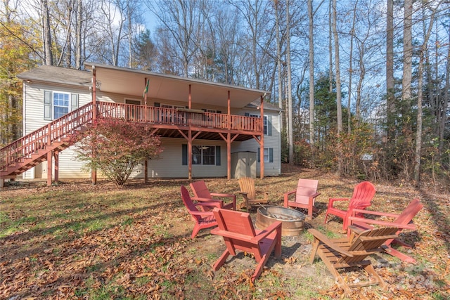 rear view of house with a deck and a fire pit