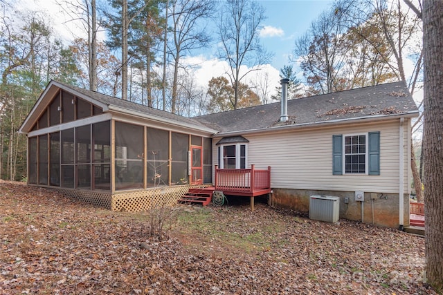 rear view of property with central AC unit, a sunroom, and a wooden deck