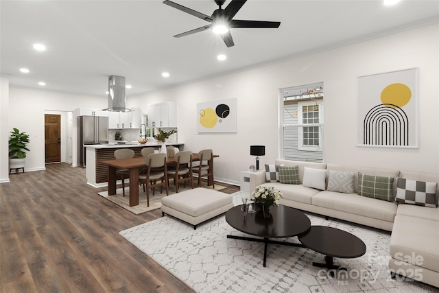 living room with ceiling fan, crown molding, and dark wood-type flooring