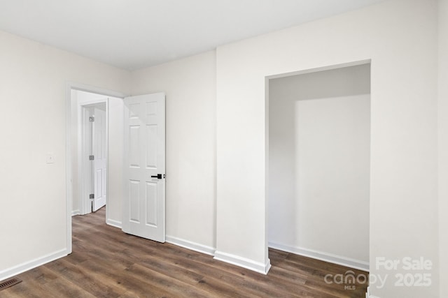 unfurnished bedroom with dark hardwood / wood-style floors