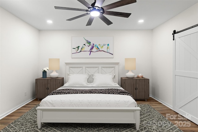 bedroom featuring a barn door, ceiling fan, and dark wood-type flooring