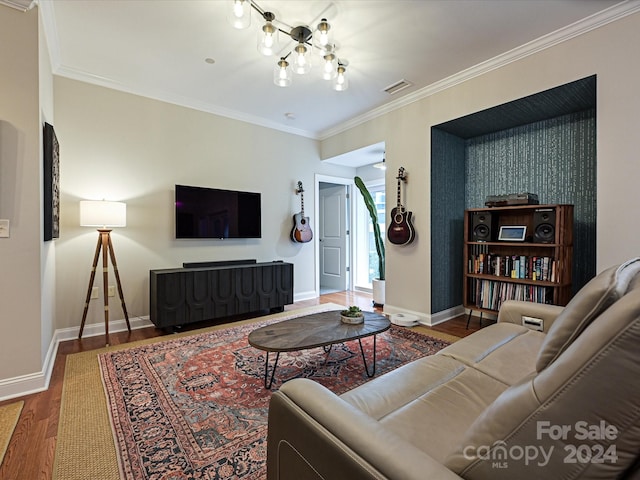 living room featuring wood-type flooring, crown molding, and a notable chandelier