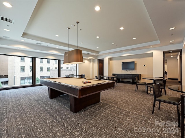 recreation room with pool table, a tray ceiling, and dark colored carpet