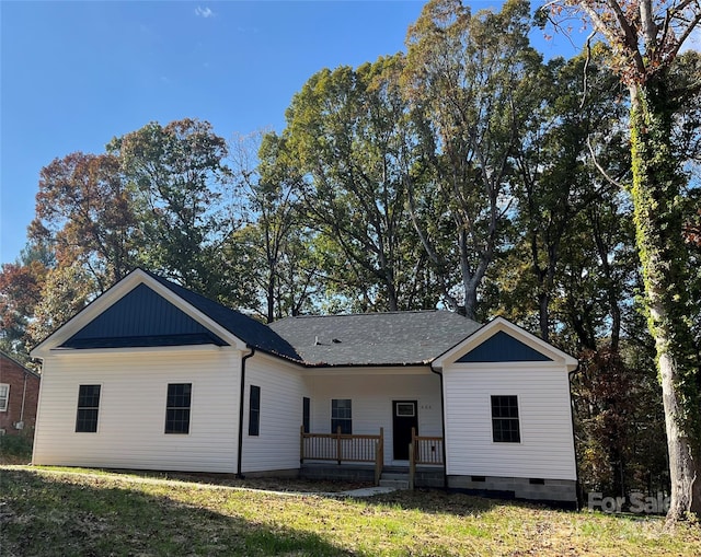 back of house featuring covered porch and a lawn