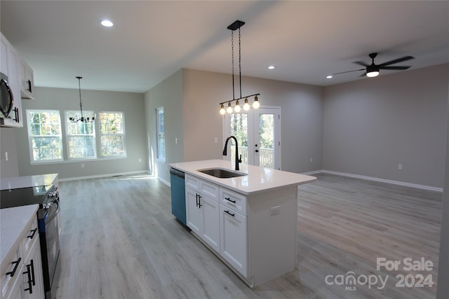 kitchen with white cabinets, plenty of natural light, a center island with sink, and appliances with stainless steel finishes