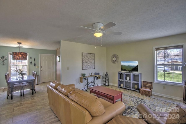 living room with ceiling fan and a textured ceiling