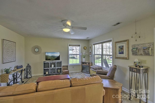 living room with a textured ceiling and ceiling fan