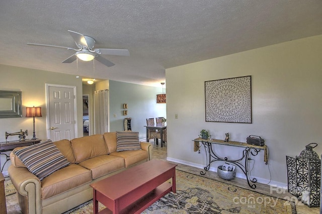 living room featuring a textured ceiling and ceiling fan