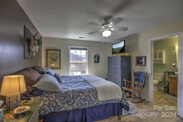 bedroom with ceiling fan, connected bathroom, and a textured ceiling