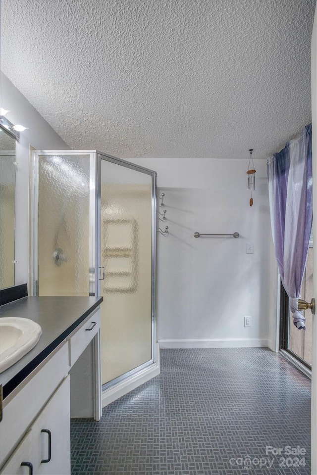 33 Summit Ln, Newland, NC 28657 - bathroom featuring a textured ceiling, vanity, a shower stall, and baseboards