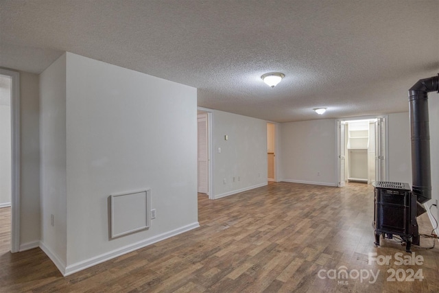 33 Summit Ln, Newland, NC 28657 - unfurnished room with a textured ceiling, wood finished floors, a wood stove, and baseboards