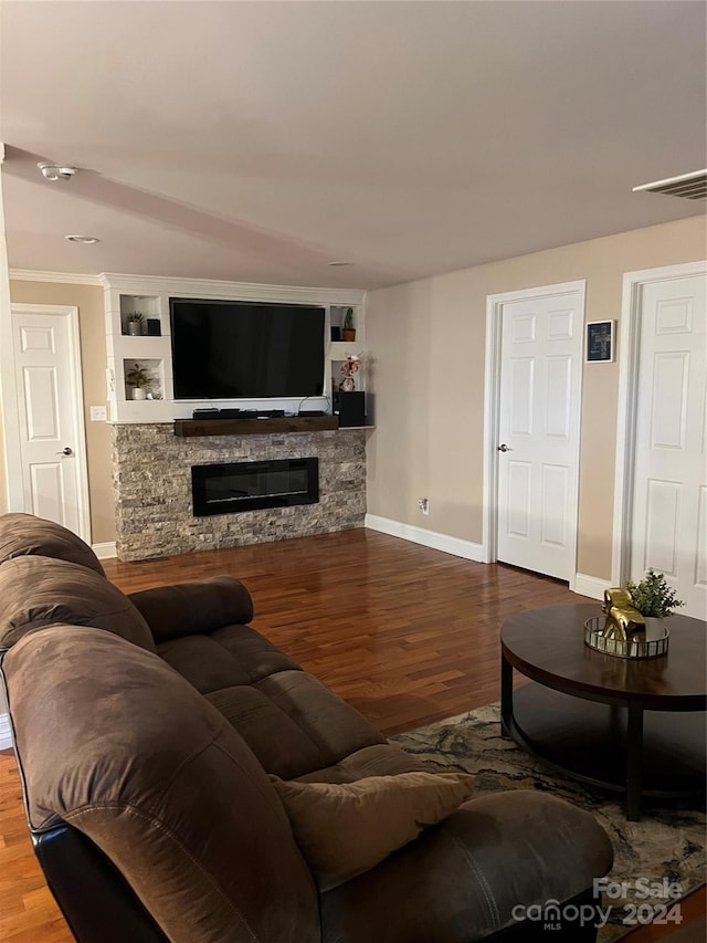 living room with a stone fireplace and hardwood / wood-style floors