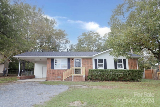 single story home with a front yard and a carport