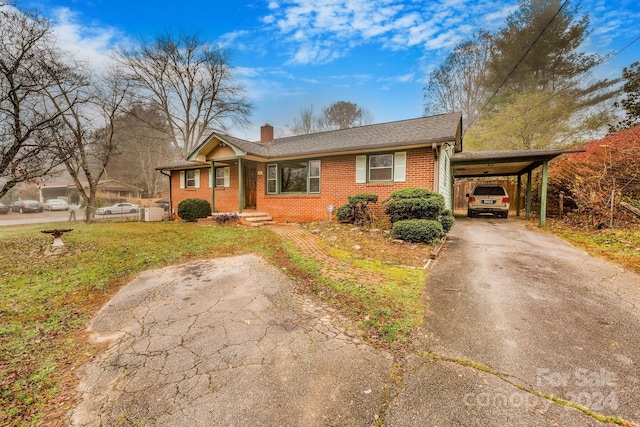 single story home with a front lawn and a carport