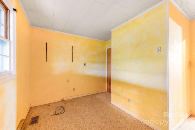 spare room with a healthy amount of sunlight, light carpet, and crown molding