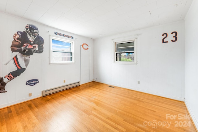 spare room with a baseboard radiator and wood-type flooring