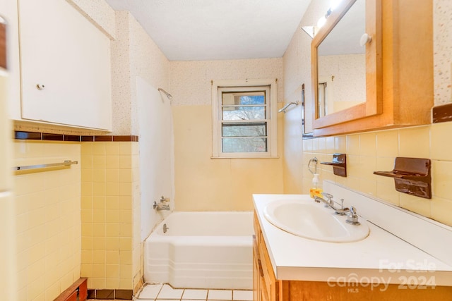 bathroom with tile walls, vanity, and tile patterned floors