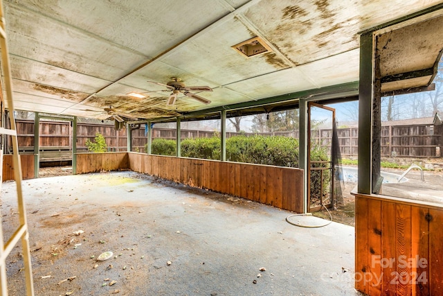 unfurnished sunroom with ceiling fan