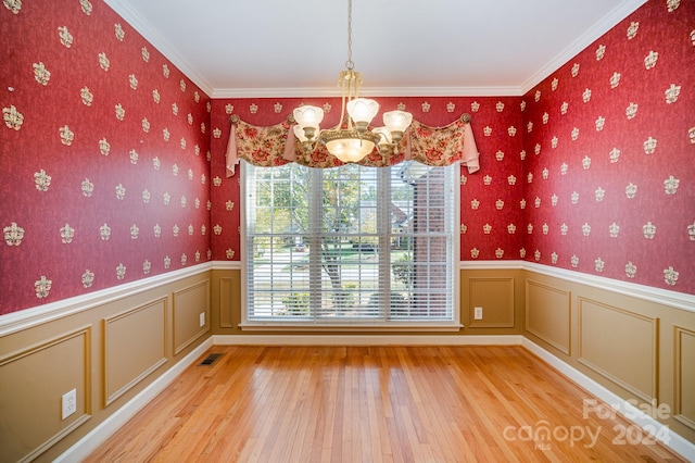 unfurnished dining area featuring a notable chandelier, light hardwood / wood-style flooring, and ornamental molding