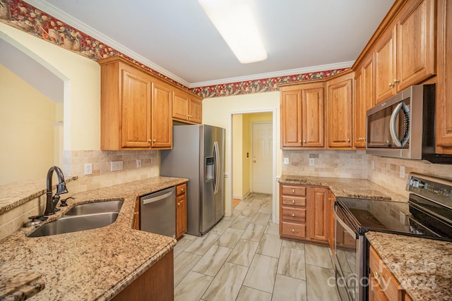 kitchen with light stone countertops, sink, appliances with stainless steel finishes, and ornamental molding