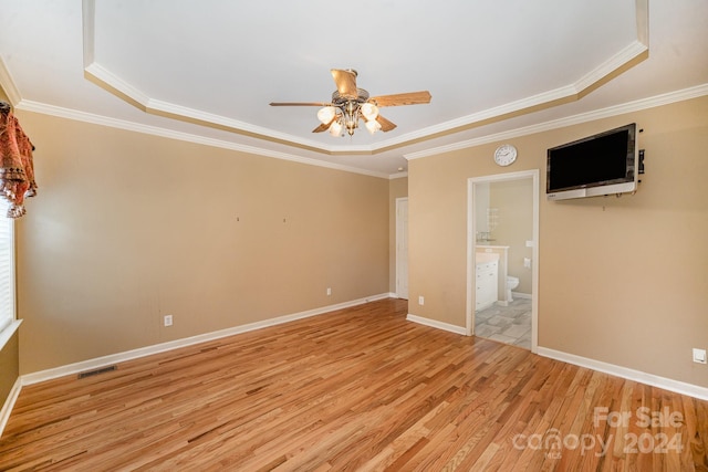 unfurnished room with light hardwood / wood-style floors, ornamental molding, and a tray ceiling