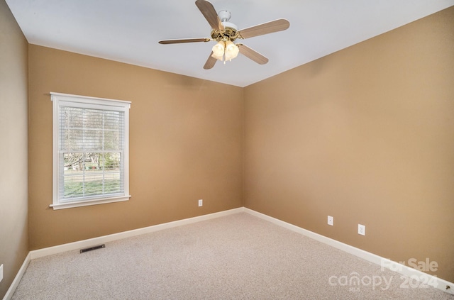 carpeted spare room with ceiling fan